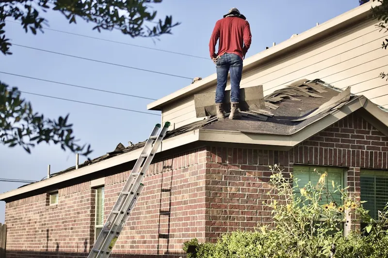 Professional roofer working on a residential roof in Adelphi
